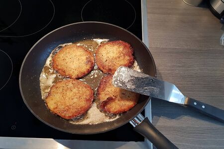 Potato pancakes in black frying pan, top viewの写真素材