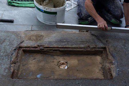 Laying ceramic floor tiles - man hands closeupの写真素材
