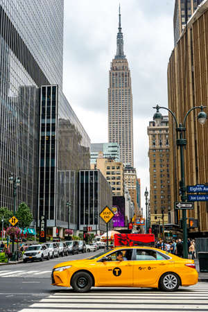 On the street near Empire state tower with yellow taxi as foreground in Manhattan , New York city , United States of America - Aug 31 , 2018のeditorial素材
