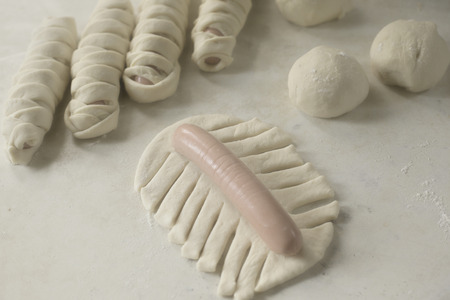 cooking homemade sausages in dough,buns with sausage close-upの写真素材