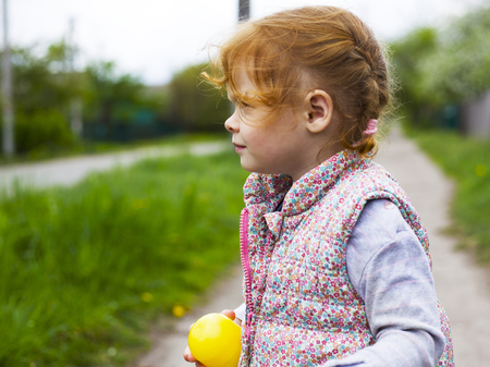 little redhead girl with pigtails looks away close-upの写真素材