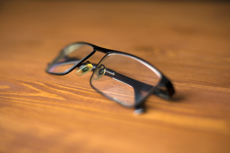glasses with clear lenses to improve vision on a wooden background with beautiful texture close-upの写真素材