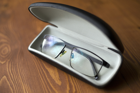 spectacles for improving sight in a case on a dark wooden background close-upの写真素材