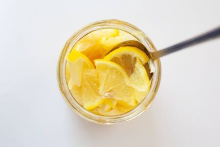 fresh lemon in sugar syrup in a jar top view close-up
