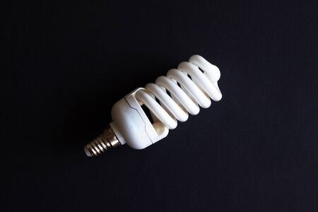 spiral energy-saving lamp on a black background close-upの写真素材