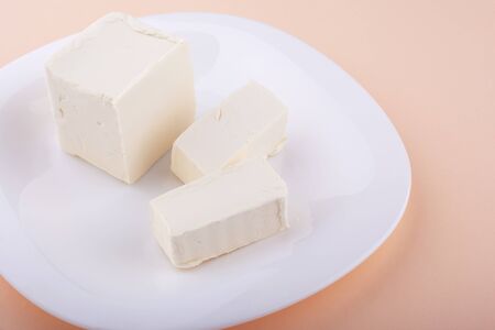 fresh chilled diced butter on a pink background close-up