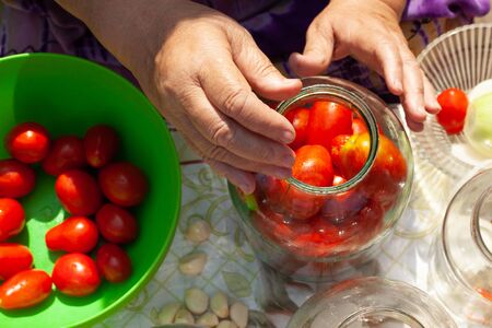 the process of canning pickles tomatoes in jars top viewの写真素材