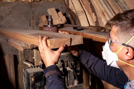 wood worker selects flat boards for the manufacture of wood products,carpenter artisan checks the...