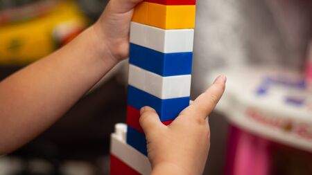 A child sitting on the floor plays with a children colorful constructor.の写真素材