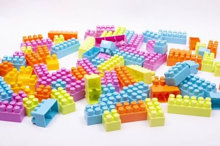 multi colored blocks of a children designer scattered on a white background.