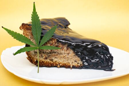 chocolate cake slice and hemp leaf. cannabis sweet food.の写真素材