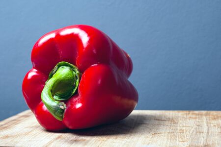 sweet red big paprika pepper on a gray background with copy space close-up.