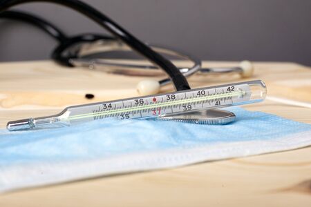thermometer stethoscope and medical disposable mask. Covid-19 flu SARS, measles, smallpox close-up...