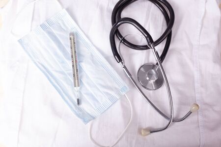 stethoscope and medical mask on a white medical coat.の写真素材
