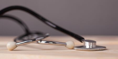 medical stethoscope on wooden table close-up.