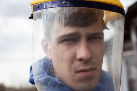 man in medical plastic face mask close-up. protection against viral flu covid-19, quarantine pandemic.の写真素材