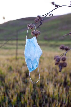 environmental pollution with medical masks, used masks on trees.