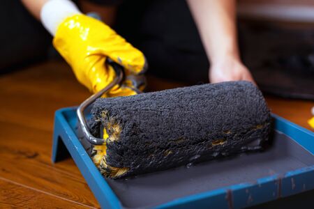 painter dips roller in a tray with paint. redecoration in the house, office.の写真素材
