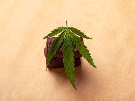 a stack of chocolates with a leaf of medical marijuana, sweets with cannabis.