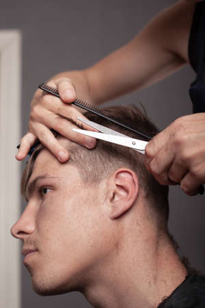 men haircut, master cuts hair with scissors close-up.の写真素材