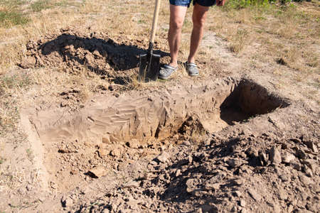 man digs a hole for a coffin in a cemetery.の写真素材