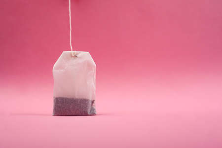 paper white tea bag on a pink background close-up, copy space.の写真素材
