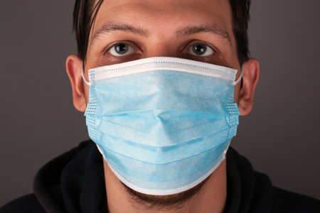 portrait of a caucasian man in a medical mask close up.の写真素材