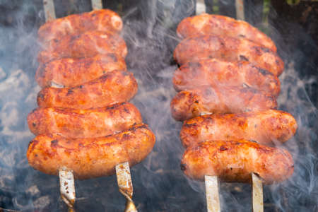 skewered pork sausages with a fried crust, grilled, food cooked in the open air close-up.