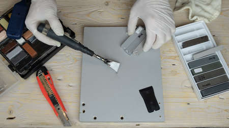 master seals the scratch with wax and a soldering iron close-up