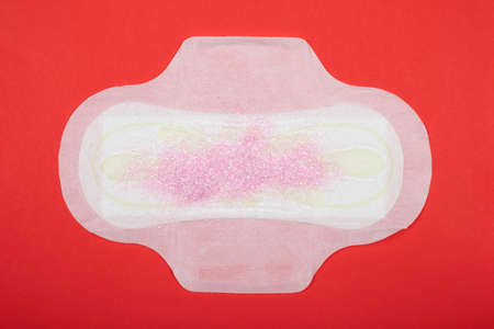 female pad on red background, symbol of menstruation in women