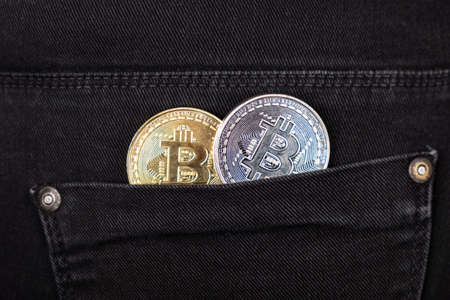gold and silver bitcoins in your pocket closeup.rise in the value of cryptocurrenciesの写真素材