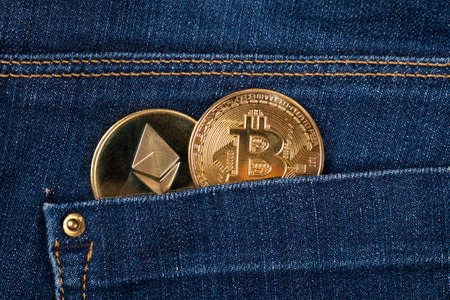 cryptocurrency, gold coins bitcoin in jeans pocket close-upの写真素材