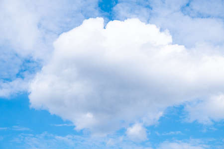 white airy porous cloud on blue sky with copy space