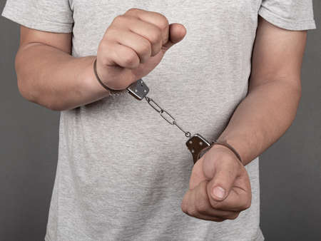 man trying to get out of handcuffs, arrested crime boss.の写真素材