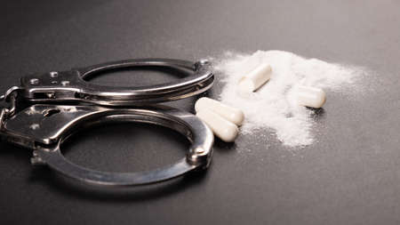 arrest of a drug dealer, handcuffs and cocaine white powder.の写真素材