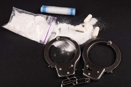 arrest of a drug dealer, handcuffs and cocaine white powder.の写真素材