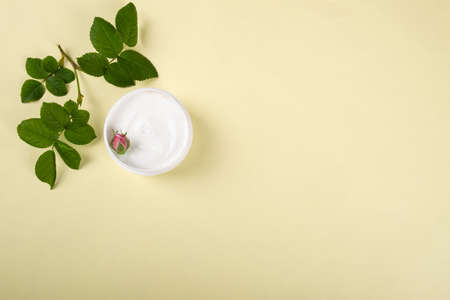 cosmetic cream with rose scent,beauty skin care flat lay with copy space on a yellow backgroundの写真素材