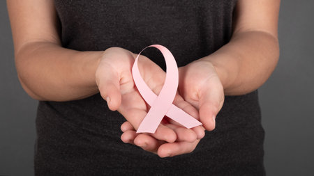 pink ribbon in the palms, breast cancer fight symbol, oncology.の写真素材