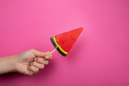 watermelon sweet lollipop candy in a woman hand
