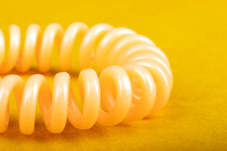spiral hair tie closeup on yellow backgroundの写真素材