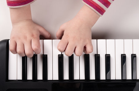 little kids hands playing piano top view, education conceptの写真素材