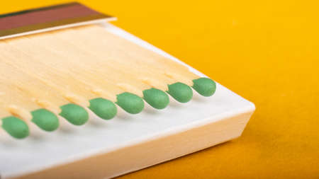 wooden matches on yellow background close up