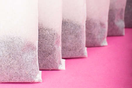 Indian black tea bags close-up on pink backgroundの写真素材