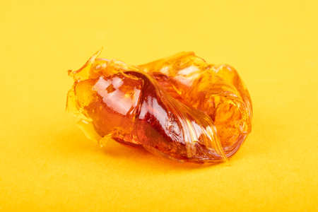 piece of cannabis concentrate wax on yellow background close-upの写真素材