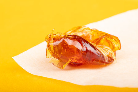 piece of resin cannabis concentrate on yellow background medical marijuana extractの写真素材