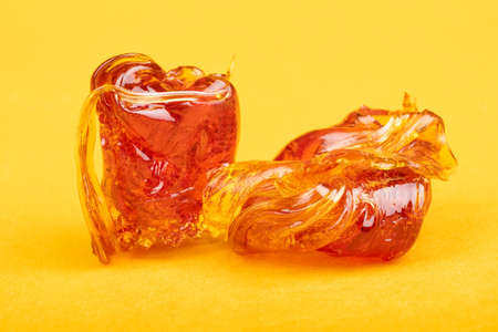 Wax hashish of marijuana concentrate on yellow background macro