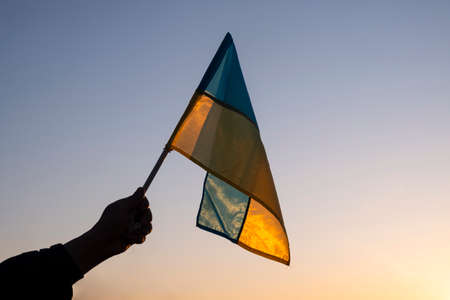 yellow blue national flag of ukraine on sunset sky background,glory to ukraine symbol