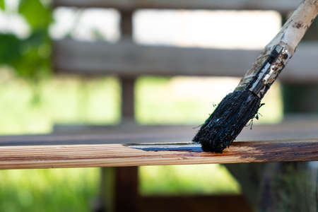 painting brush a wooden surface with a dark varnishの写真素材