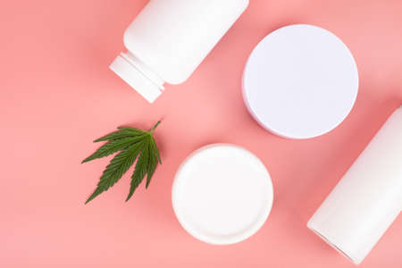 medical cosmetic set based on marijuana, white bottles with lotion and cream and green marijuana leafの写真素材