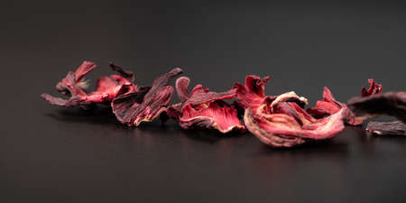 dried hibiscus tea petals on a dark background macro closeupの写真素材